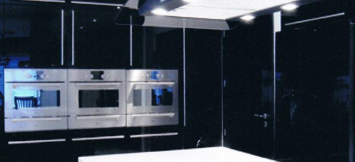 Black gloss doors with glacier white corian worktops and end panels with a corian sink