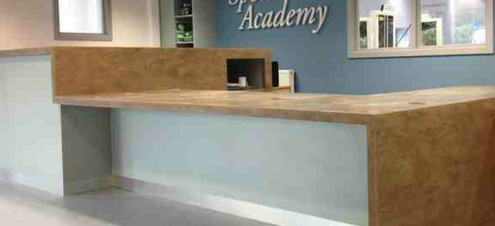 Sports Academy reception counter – Stoke Tops made up from corian. Front from mr mdf laminated in grey formica . Plinth in brushed aluminium abet laminate. All relevant DDA compliant . 